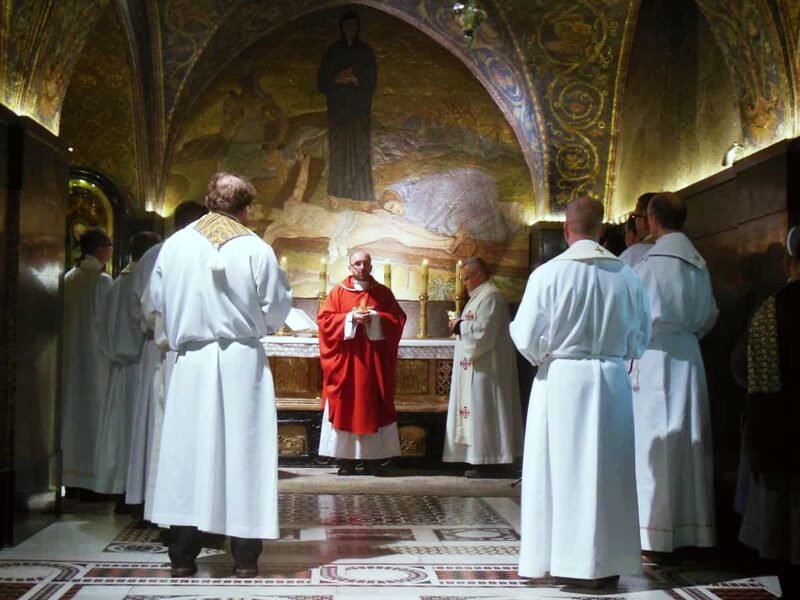 Clergy in albs at mass inside the Church of the Holy Sepulchre.